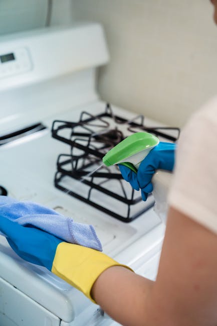 A professional cleaner from Hampstead Cleaner engaged in domestic surface cleaning during an end of tenancy cleaning service at a residential property. The cleaner is holding a plastic bucket filled w